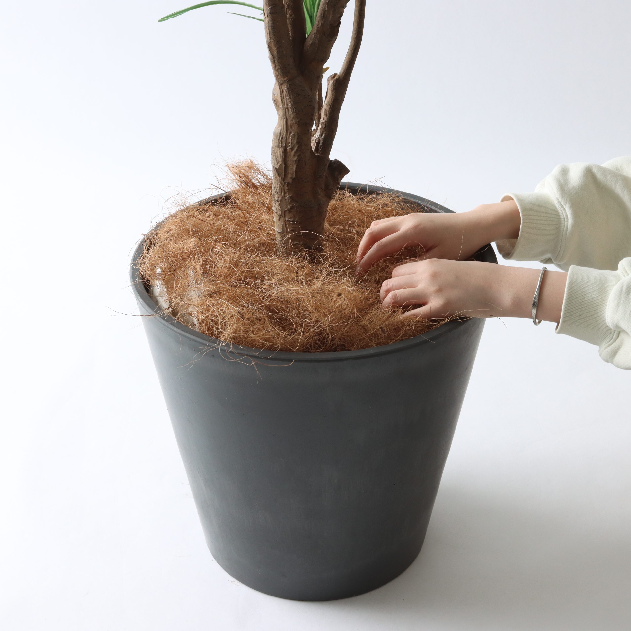 ヤシの繊維をほぐしながら詰める